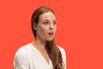 Image showing Beautiful woman looking suprised isolated on red