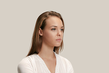 Image showing The serious business woman standing and looking at camera against gray background.