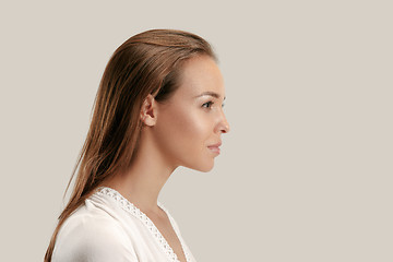 Image showing The serious business woman standing and looking at camera against gray background.