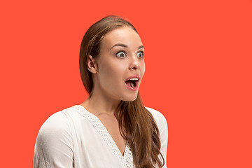 Image showing Beautiful woman looking suprised isolated on red