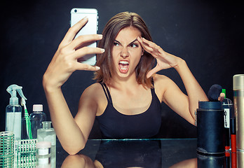 Image showing Beauty woman with makeup. Beautiful girl looking at the mobile phone and making selfie photo