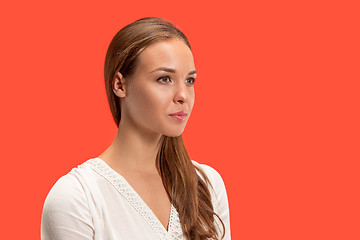 Image showing The serious business woman standing and looking at camera against red background.