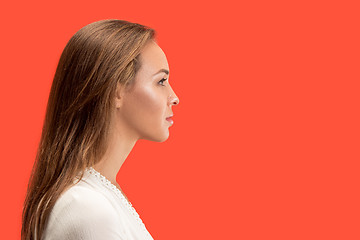 Image showing The serious business woman standing against red background.