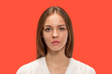 Image showing The serious business woman standing and looking at camera against red background.