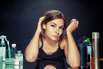 Image showing Beauty woman after applying makeup. Beautiful girl looking in the mirror and applying cosmetic with a brush.