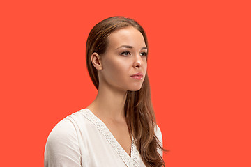 Image showing The serious business woman standing and looking at camera against red background.