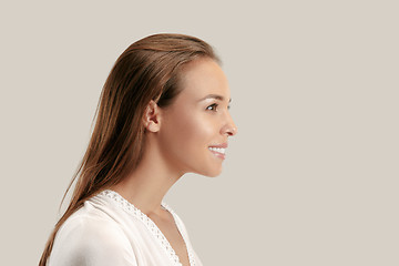 Image showing The happy business woman standing and smiling against gray background.