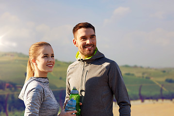 Image showing couple with bottles of water after sports outdoors