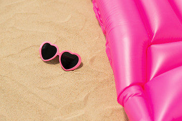 Image showing sunglasses and pink swimming mattress on beach