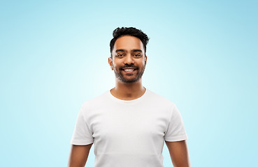 Image showing smiling young indian man over blue background