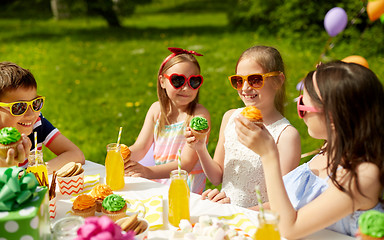 Image showing kids eating cupcakes on birthday party in summer