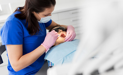 Image showing dentist checking for kid teeth at dental clinic