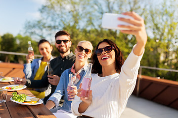 Image showing happy friends taking selfie at rooftop party