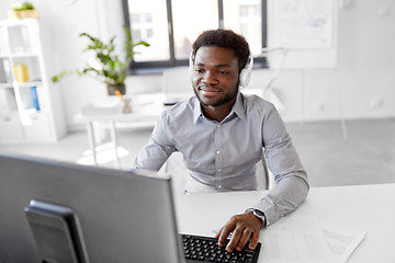 Image showing businessman with headphones and computer at office