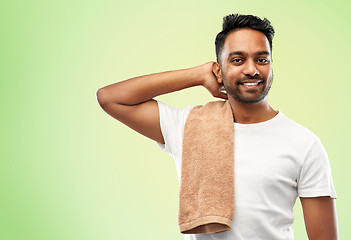 Image showing smiling indian man with towel over green 