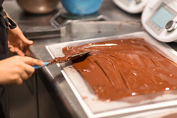 Image showing confectioner makes chocolate dessert at sweet-shop