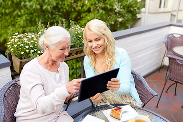 Image showing daughter with tablet pc and senior mother at cafe