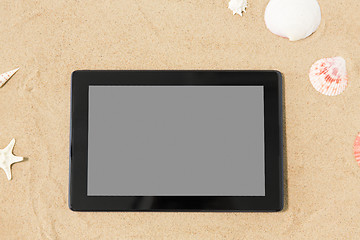 Image showing tablet computer and seashells on beach sand