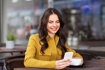 Image showing teenage girl with smartphone and hot drink at cafe