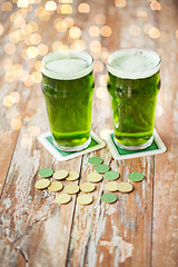 Image showing glasses of green beer and gold coins on table