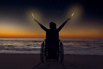 Image showing Handicapped woman holding fire sparklers