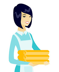 Image showing Young asian housekeeping maid with stack of linen.