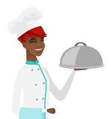 Image showing Young african chef holding towel and cloche.