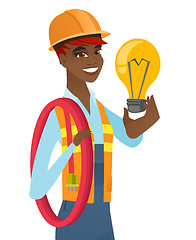 Image showing African-american electrician holding lightbulb.