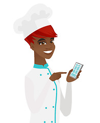 Image showing Young african-american chef holding mobile phone.