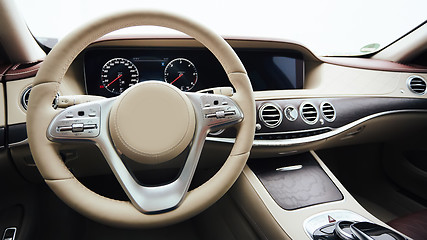 Image showing Car interior luxury. Interior of prestige modern car. Leather comfortable seats, dashboard and steering wheel. White cockpit with exclusive wood and metal decoration