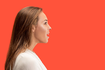 Image showing Beautiful woman looking suprised isolated on red