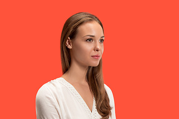 Image showing The serious business woman standing and looking at camera against red background.