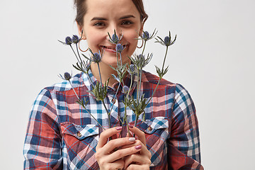 Image showing Pretty girl with flowers eryngium