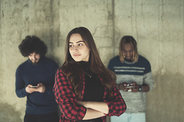 Image showing casual multiethnic business team using mobile phones in front of