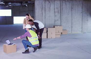 Image showing engineer showing house design plans to a young multiethnic coupl