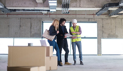 Image showing architect showing house design plans to a young couple