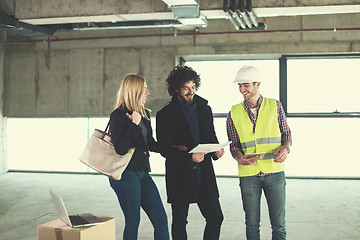 Image showing architect showing house design plans to a young couple