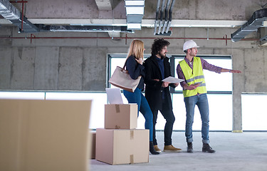 Image showing architect showing house design plans to a young couple