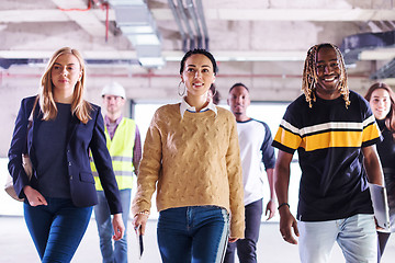 Image showing young multiethnic business people walking through unfinished sta