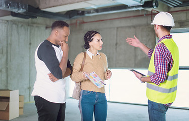 Image showing architect showing house design plans to a young multiethnic coup