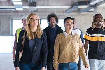 Image showing young multiethnic business people walking through unfinished sta