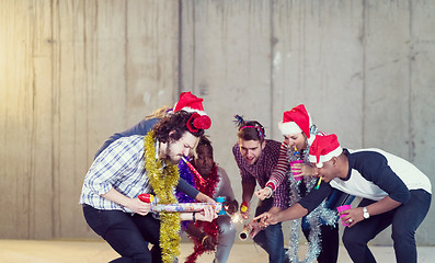 Image showing multiethnic group of casual business people lighting a sparkler