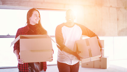 Image showing multiethnic business team carrying cardboard boxes