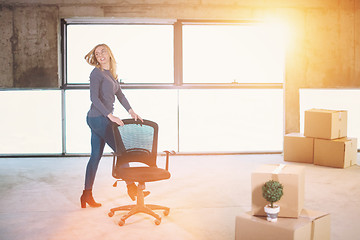 Image showing business woman pushing office chair