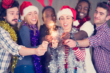 Image showing multiethnic group of casual business people lighting a sparkler