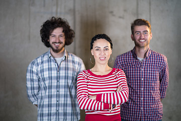 Image showing portrait of casual business team in front of a concrete wall