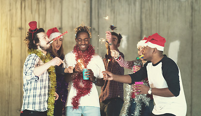 Image showing multiethnic group of casual business people lighting a sparkler