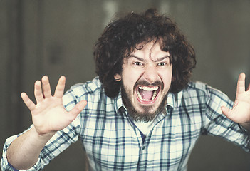 Image showing casual businessman screaming in front of a concrete wall