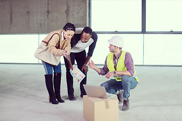 Image showing engineer showing house design plans to a young multiethnic coupl