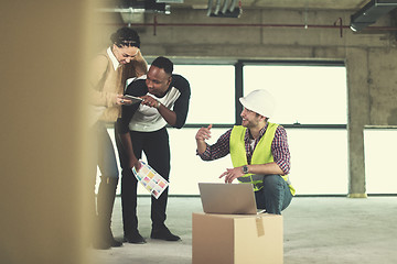 Image showing engineer showing house design plans to a young multiethnic coupl